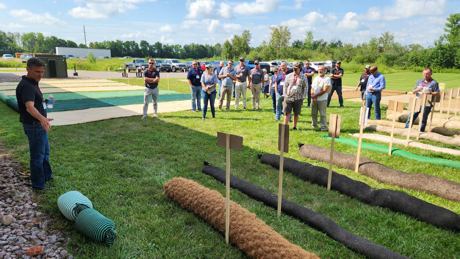 Attendees at an MKB product demonstration, with erosion control blankets, wattles and coir logs laid out on the ground