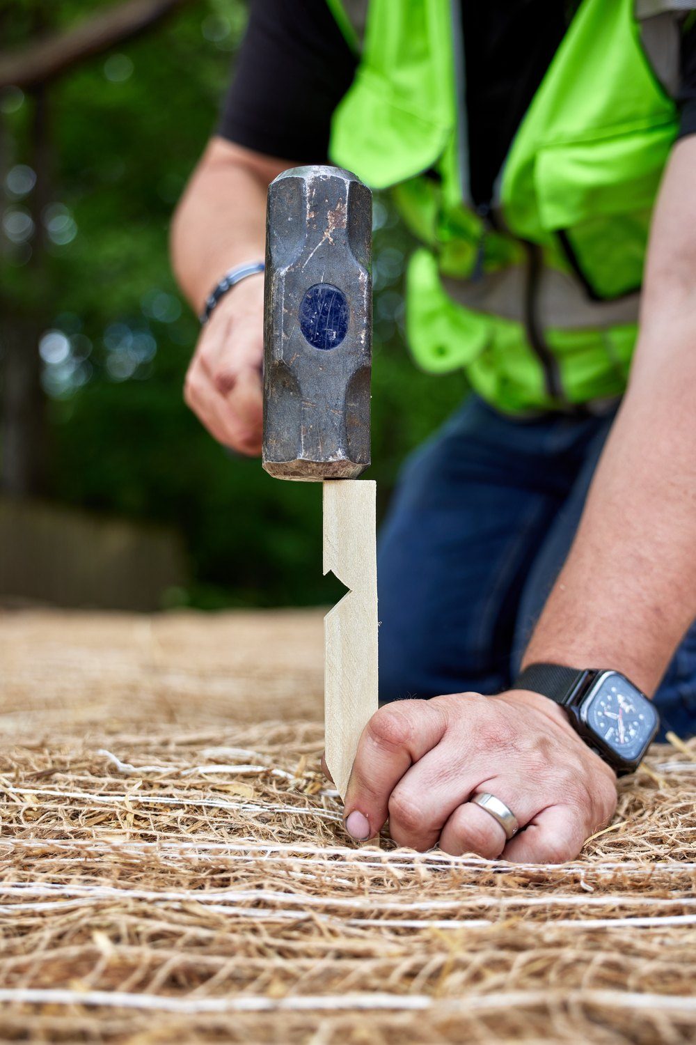 Installer driving an Eco-Peg wood stake with a mallet